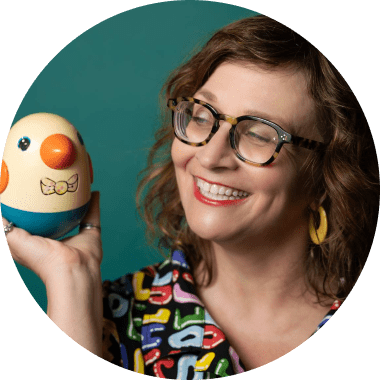 Martha Chang holding a vintage Playskool chicken, cheerful mascot of Chick Creative